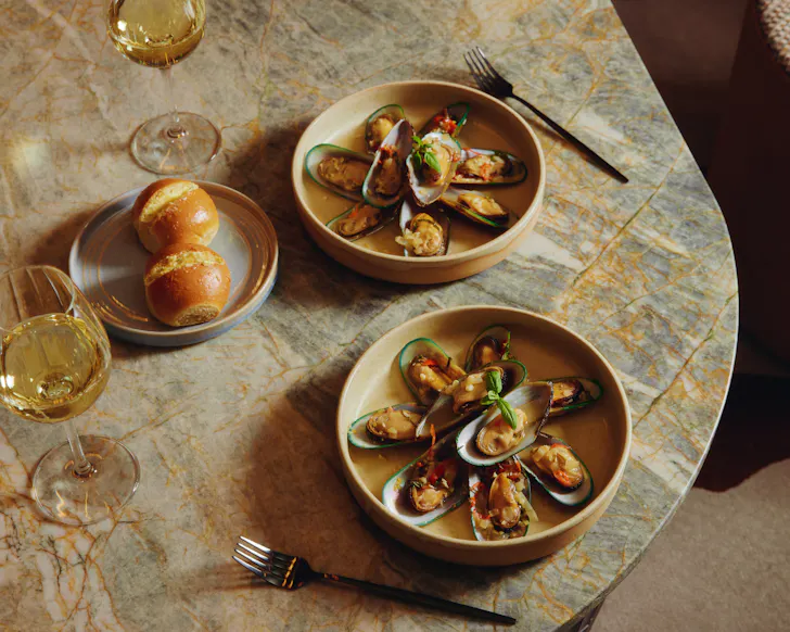 Pre-dinner snacks at Six to Midnight at Avani Queenstown, including oysters and soft buns.