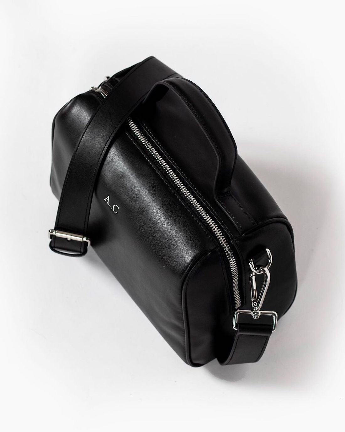 A black vegan leather handbag sits unopened.