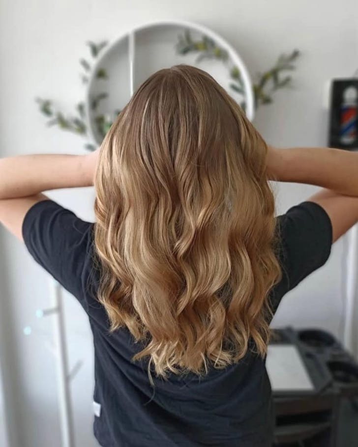Woman posing with her beautiful hair after a hair cut in the salon.