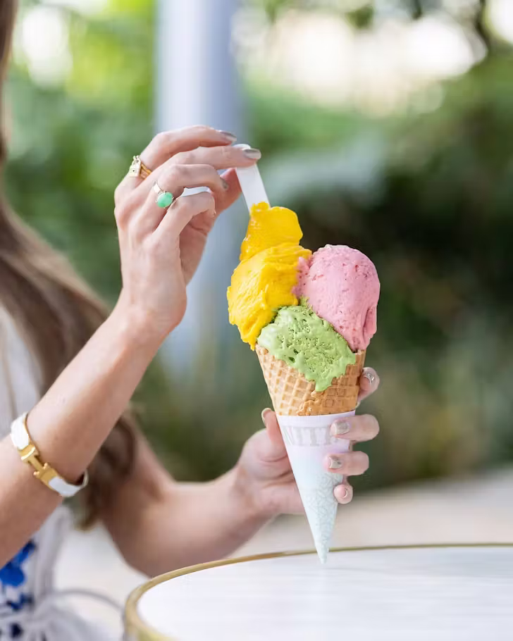 A woman holds a three scoop ice cream (@anitagelato_australia)