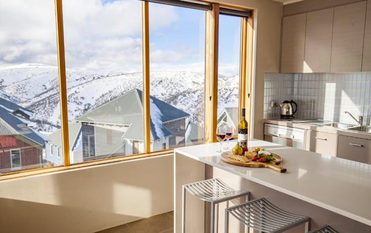 A kitchen that looks out onto the snow mountains, a top mt hotham accommodation. 