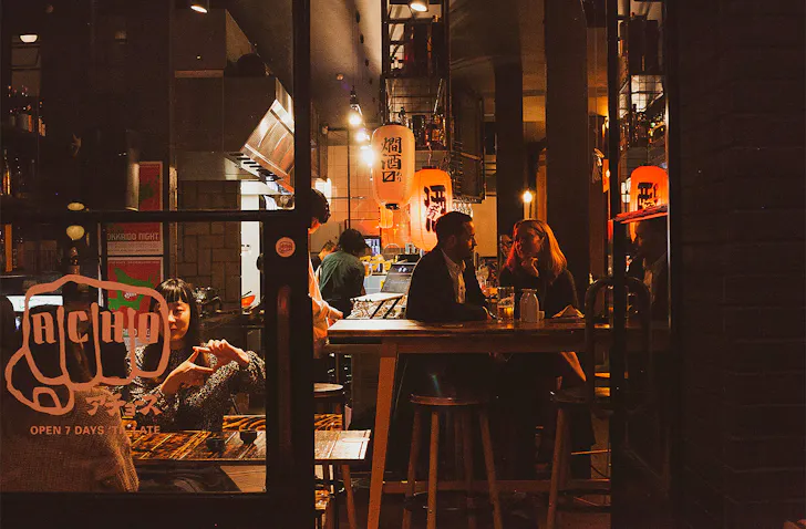 People sitting at Acho's, one of the best late-night spots on K'Road.