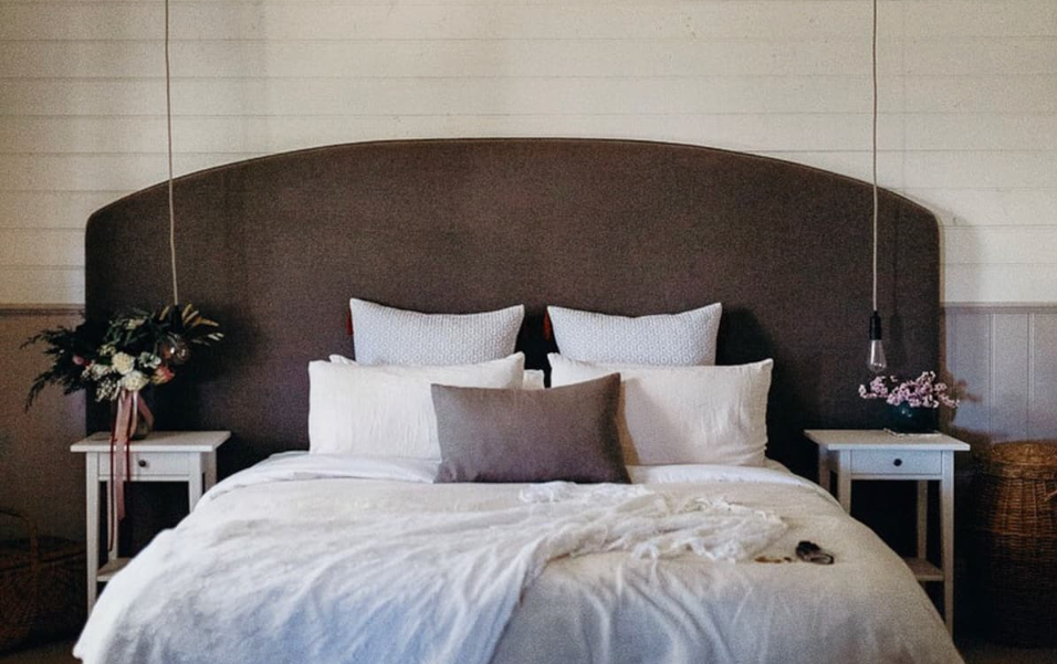 A bed with pillows stacked inside a best romantic getaway Victoria.