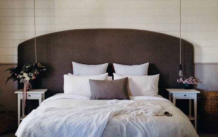 A well made bed with pendant hanging lights, Daylesford accomodation. 