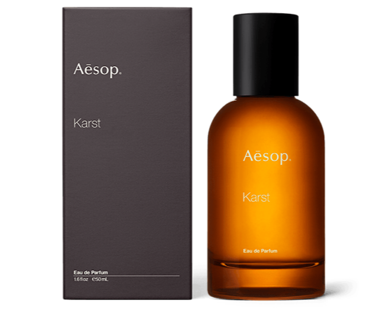 A glass bottle of Aēsop. Karst Eau de Parfum stands beside its dark grey box. 