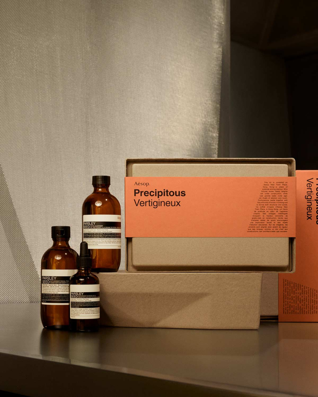 3 brown glass bottles beside a brown paper box with an orange sleeve that says 'Precipitous'.