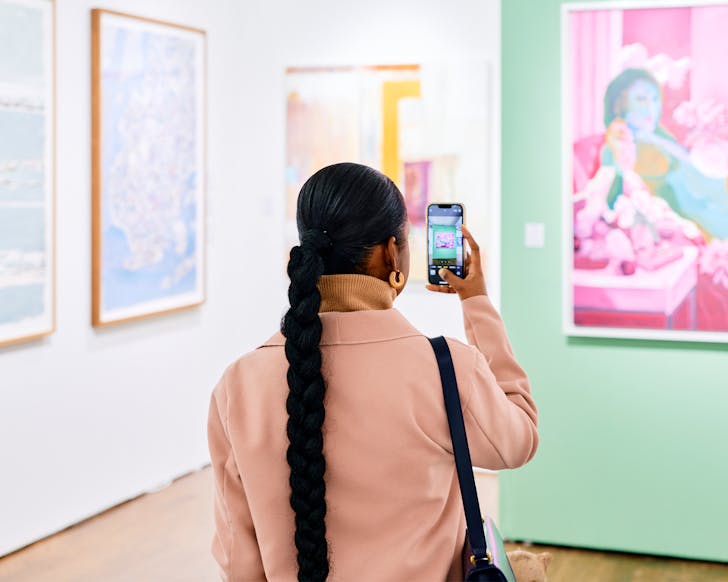 a woman taking a picture in an art gallery