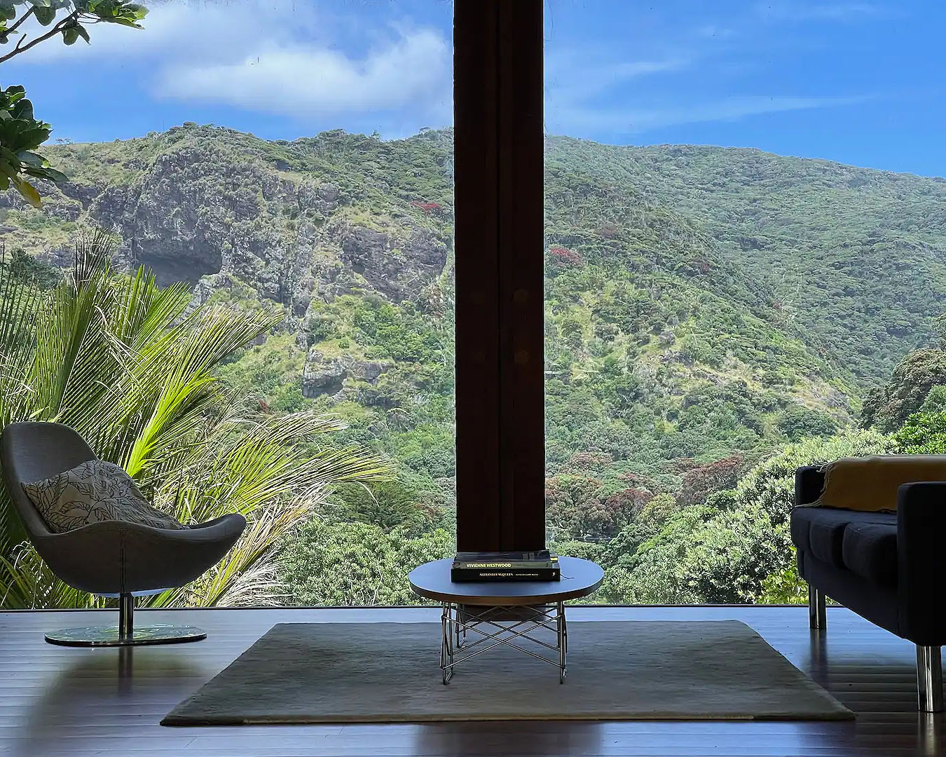 Floor to ceiling windows look out onto lush greenery, one of the best airbnbs with fireplaces in New Zealand.