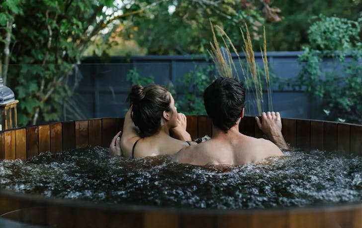 Two people sitting in a cedar spa in Victoria. 