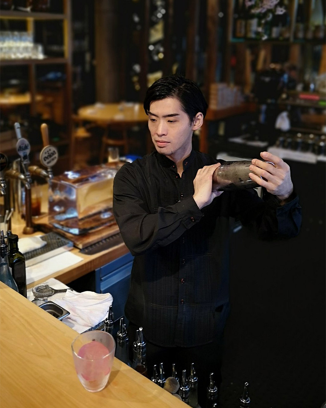 Akira mixes a drink behind the bar at MASU.