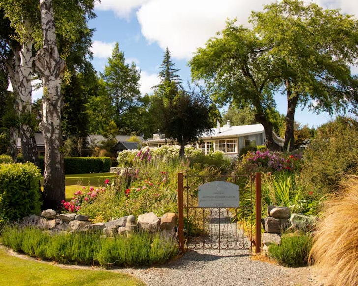 An exterior view of Aldourie Lodge surrounded by gardens, one of the best accommodation options in Lake Tekapo New Zealand