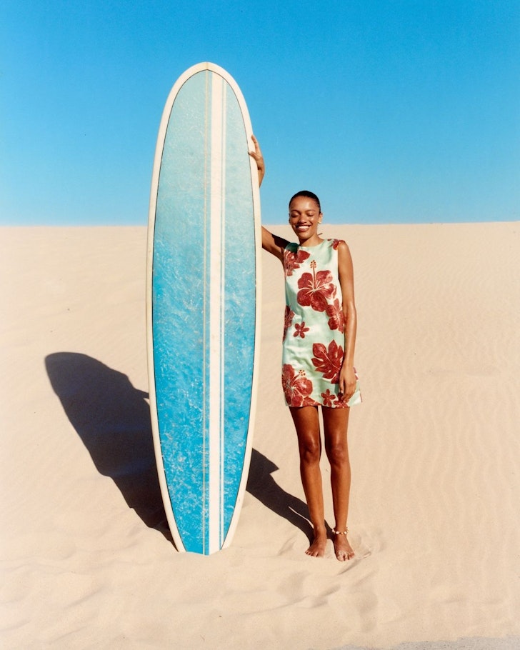 A model holds a surfboard while wearing the Sizzle Mini from Alemais one of the best Australian fashion labels