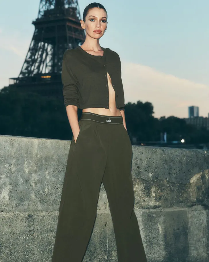 A woman wears the olive green Suit Up Trouser from Alo Yoga one of the best activewear brands