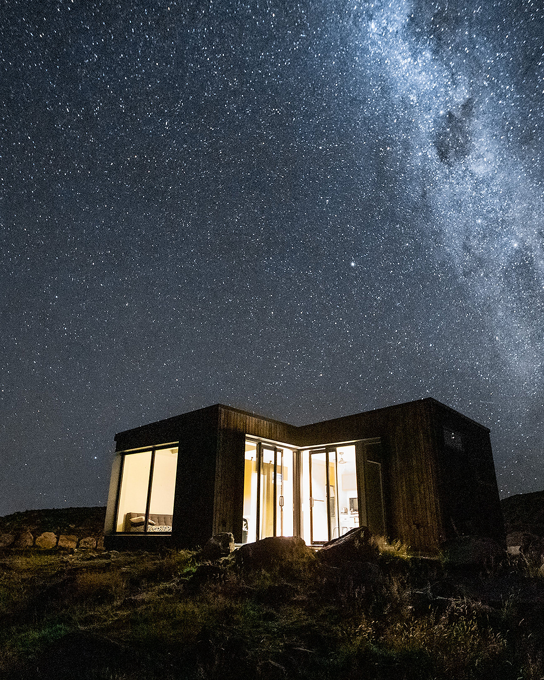 A house seen outside under a starry sky.