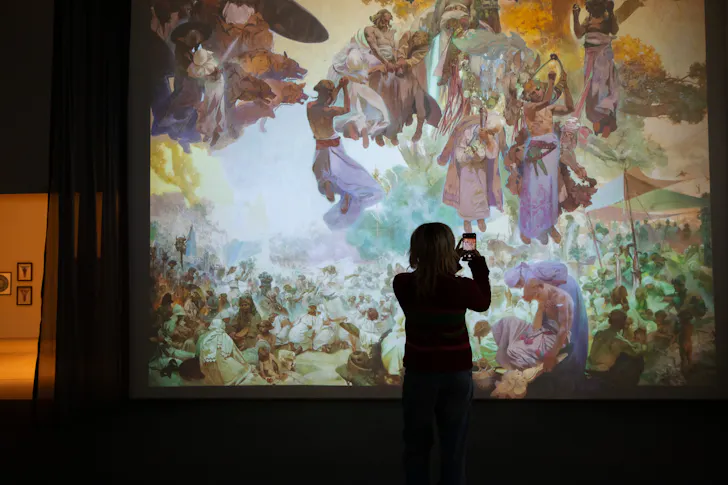 Person taking photo of art on wall.