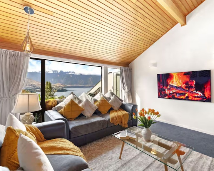 The living space at Alpine Gold romantic stay in New Zealand with timber-clad roof, gold styling and mountain view