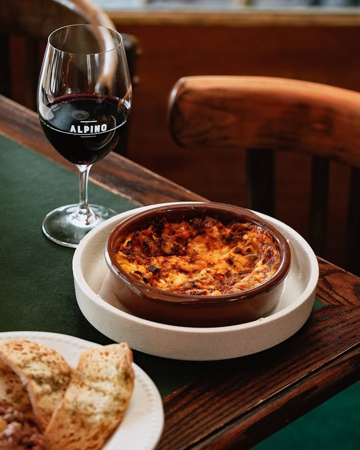 Lasagna accompanied by a glass of red at Alpino. 