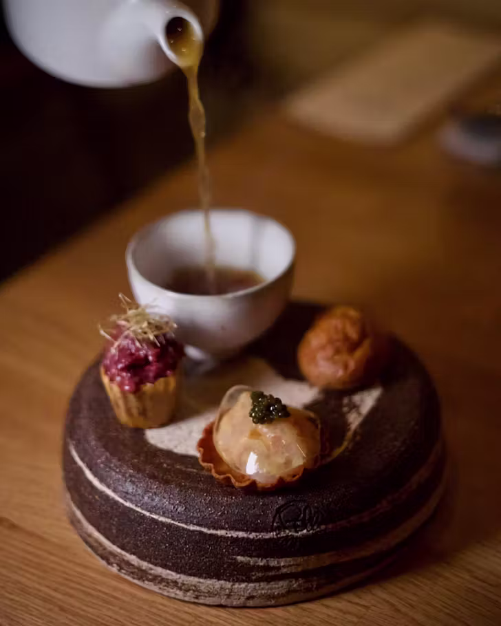 A waiter pouring sauce over a curated dish at Ame, Barcelona.