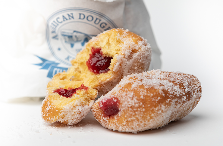 American Doughnut Kitchen serving some of the best doughnuts in Melbourne, in now opening a store in Prahran Market. This is a photo of three sugar-coated hot jam doughnuts. 
