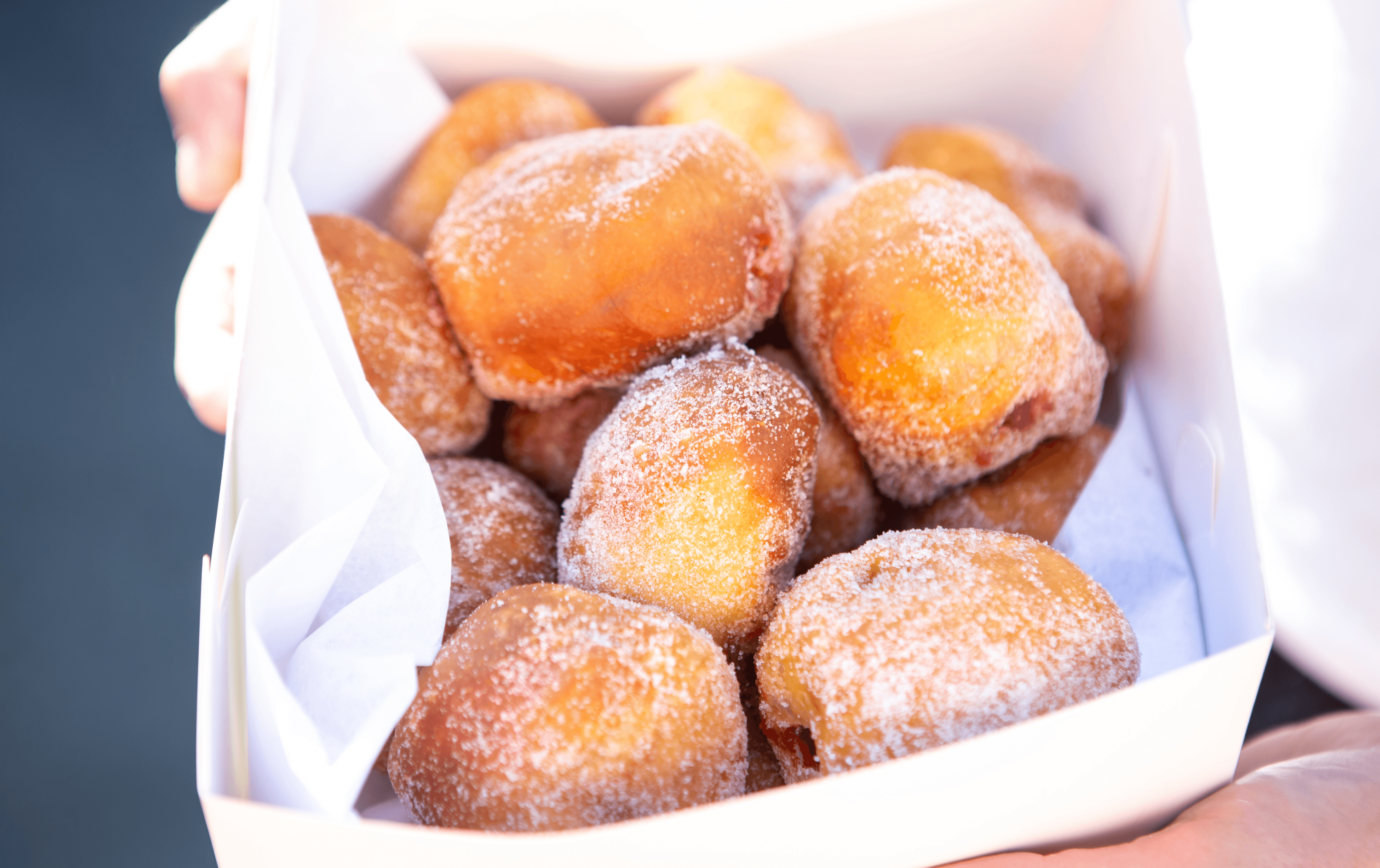 A white paper bag with a selection of the top donuts Melbourne has to offer.  