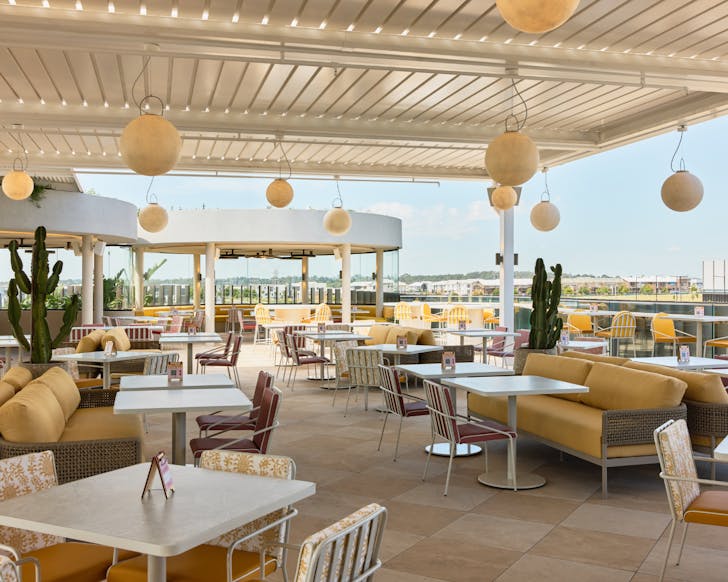 An open rooftop bar set with fire pits and couch seating overlooking a panoramic view of Oran Park