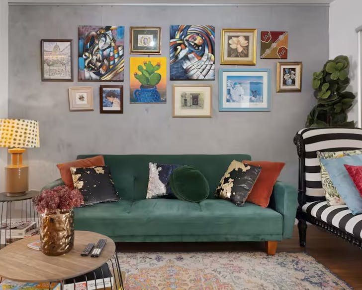 A jewel-coloured green lounge in the living space of this Artsy Terrace Short Term Rental in Darlinghust, Sydney
