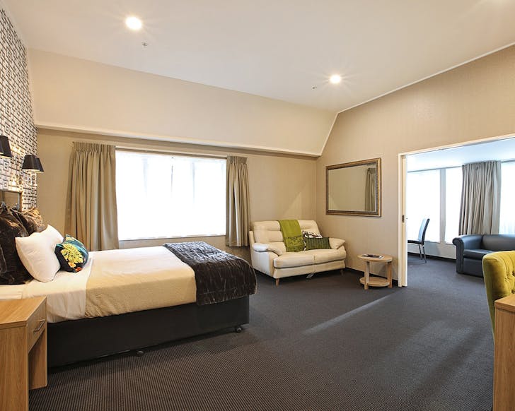 A nice looking room with a sitting room seen through the door.