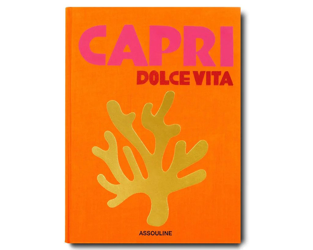 An orange hardcover book with a gold illustration of coral and 'capri' in bright pink letters