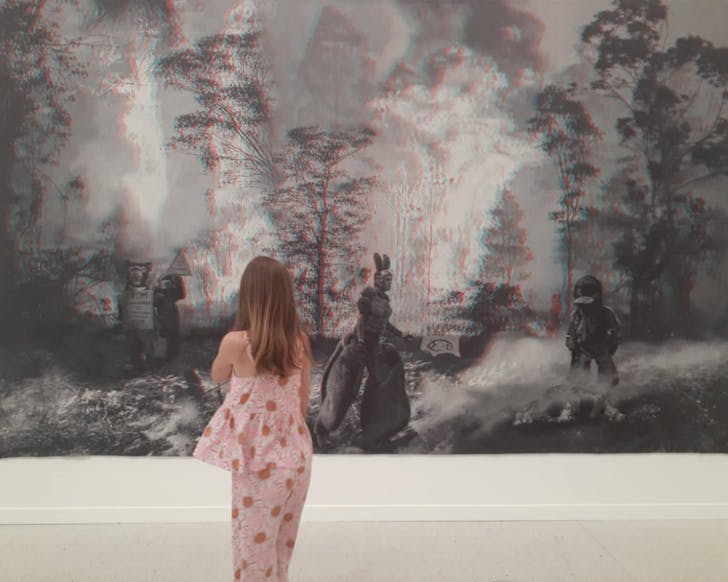 A young girl stands in awe of a large black and white artwork at Auckland Art Gallery. 