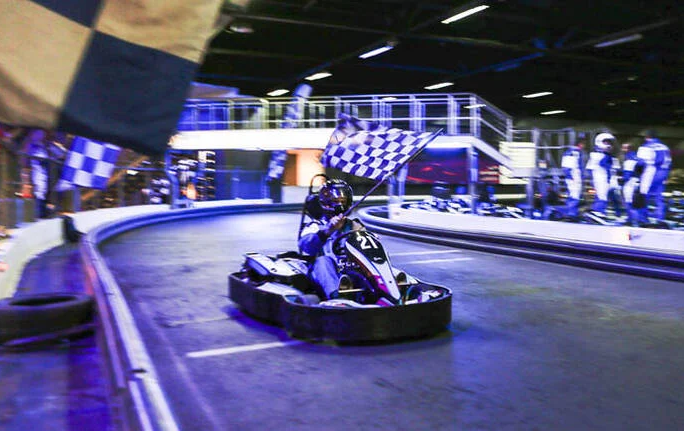 A person go karting around an inside track, one thing to do in Melbourne. 