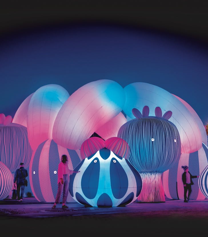 People wander through a huge colourful, inflated installation. 