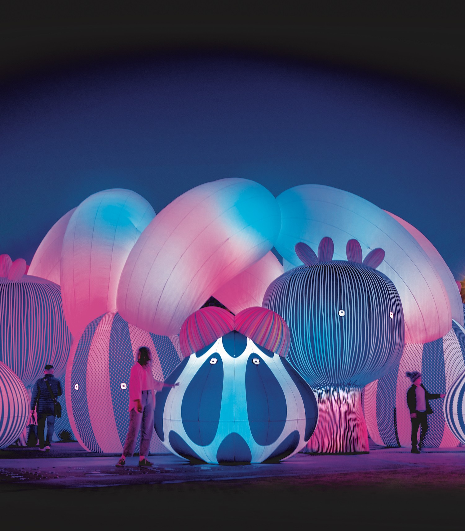 People wander through a huge colourful, inflated installation. 