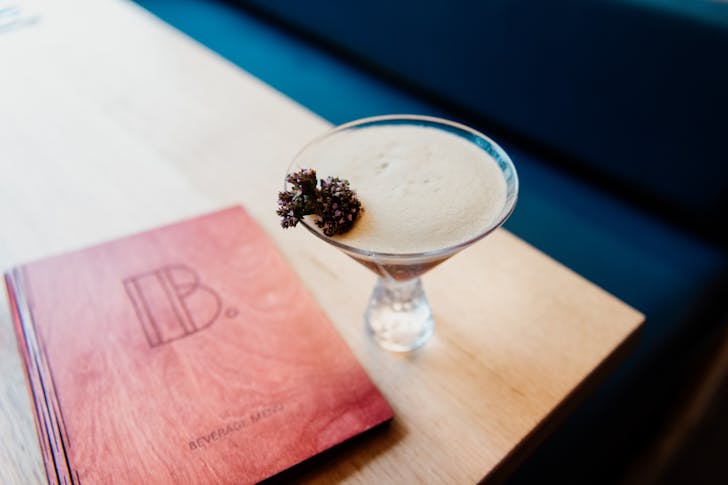 an espresso martini beside a menu engraved with a B