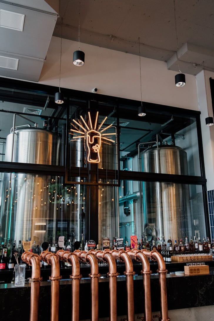 copper beer taps and beer vats in a brewery