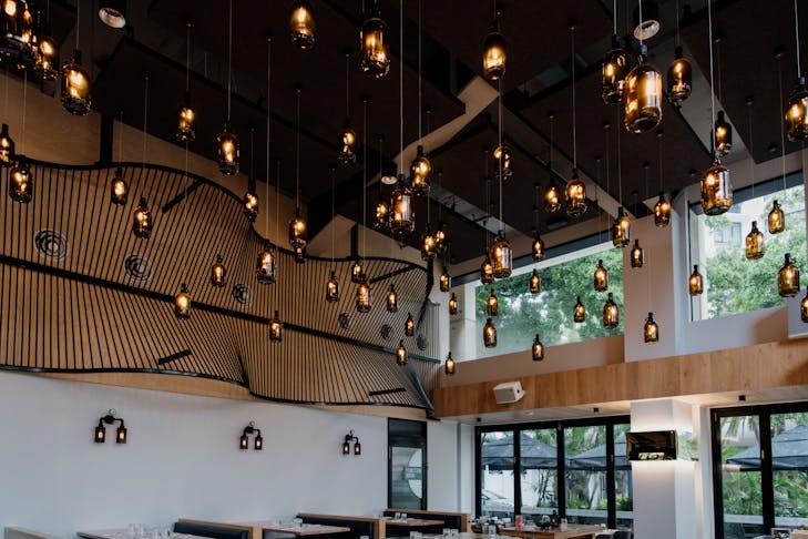 beer bottle lamps hanging from the ceiling of a brewpub
