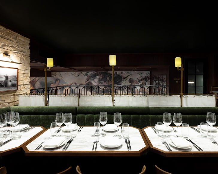 Shining tables, a dark green banquette seating aesthetic and mini lights at Bossi.