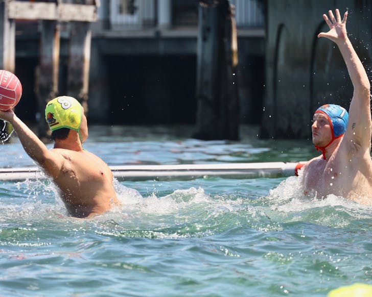 Two people throwing waterpolo ball