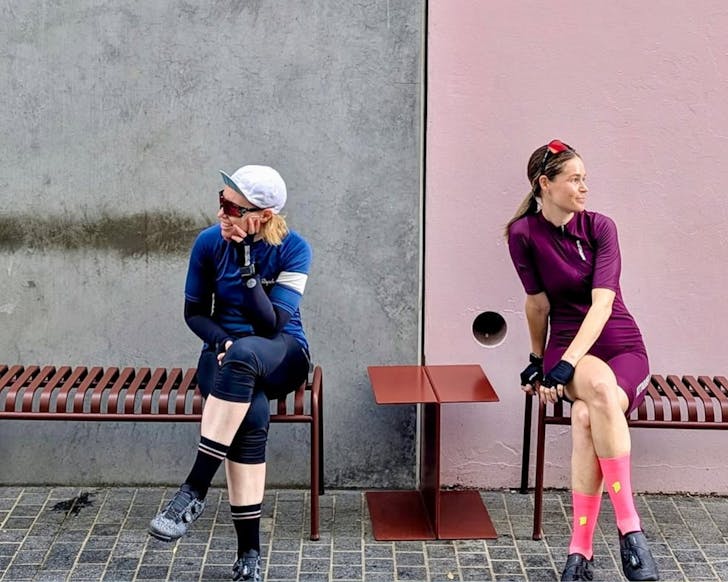 Two people on chairs in front of wall