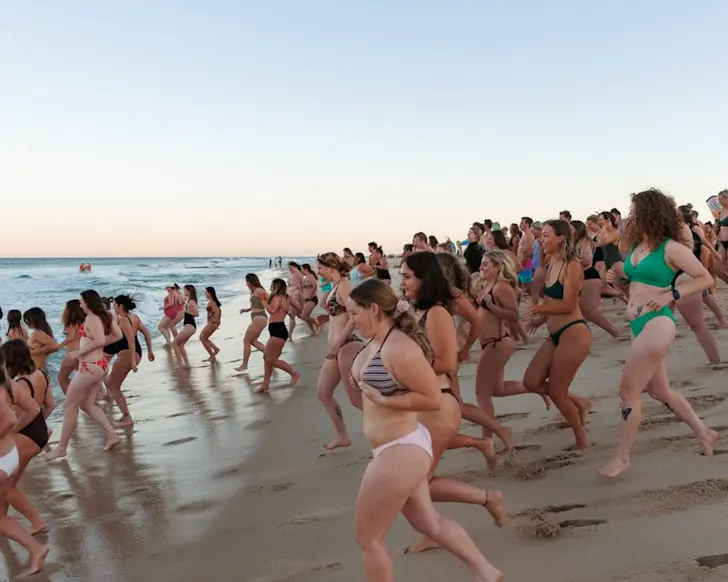 Group of women running into water
