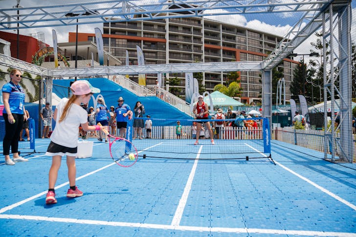 Kid hitting tennis ball on court
