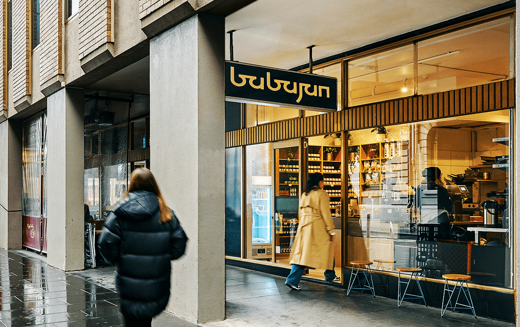 The outside storefront of Babajan in the city with a person walking past. 