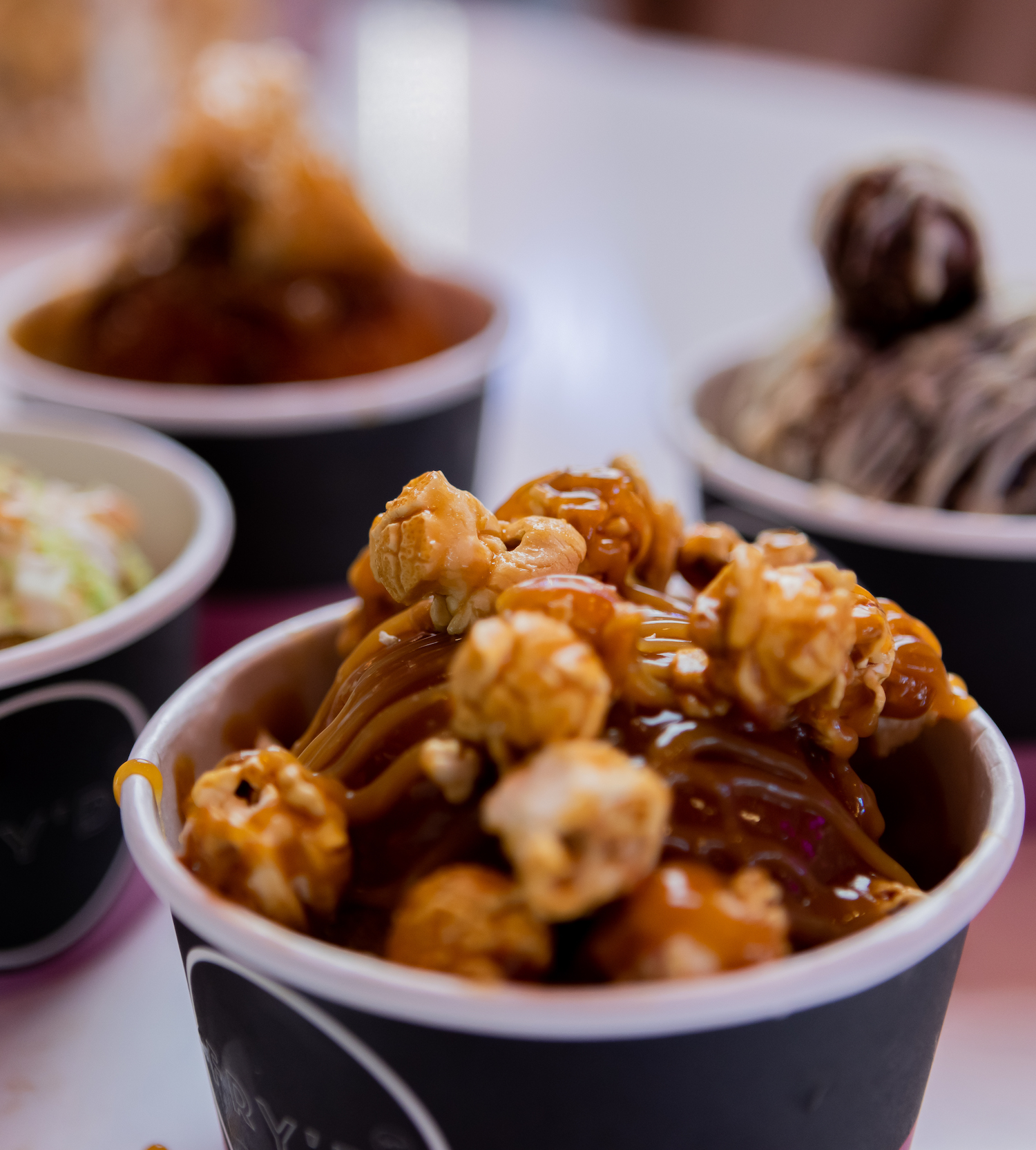 Deep-fried ice cream topped with pop corn sits in a takeaway bowl.