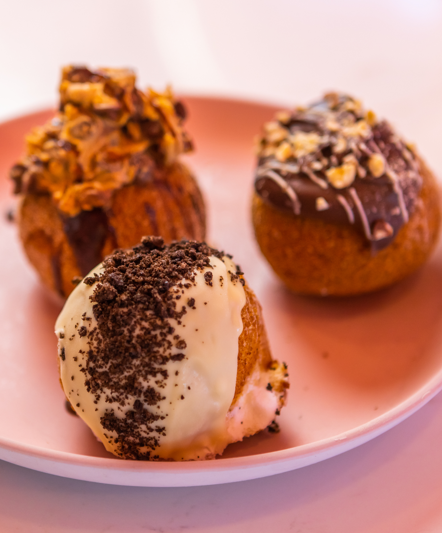 Three deep-fried ice cream balls are topped with delicious syrups.