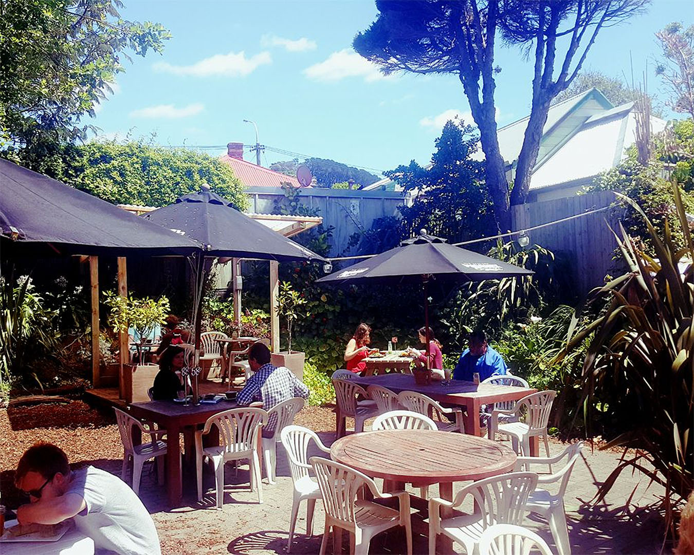 People relax in the outside garden at Baobab Cafe, one of the best breakfasts in Newtown, Wellington.