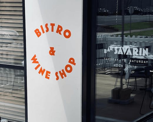 A white wall that has bistro and wine shop written in red.