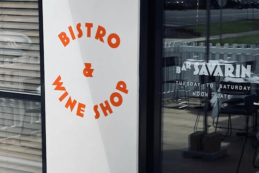 A white wall that has bistro and wine shop written in red.