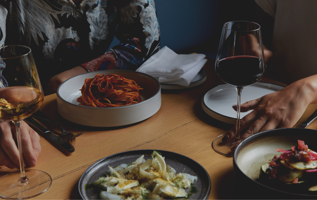 A table with a pasta dish and wines at one of the best Italian restaurants in Melbourne.
