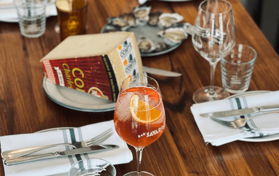 A table set with cutlery glasses and cheese.