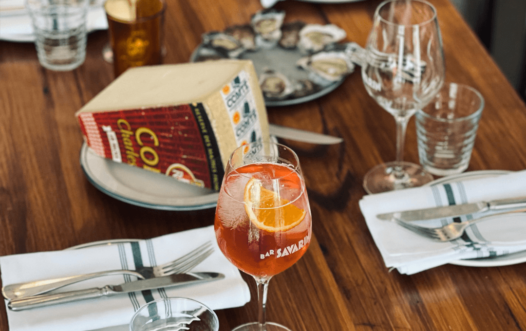 A table set with cutlery glasses and cheese.