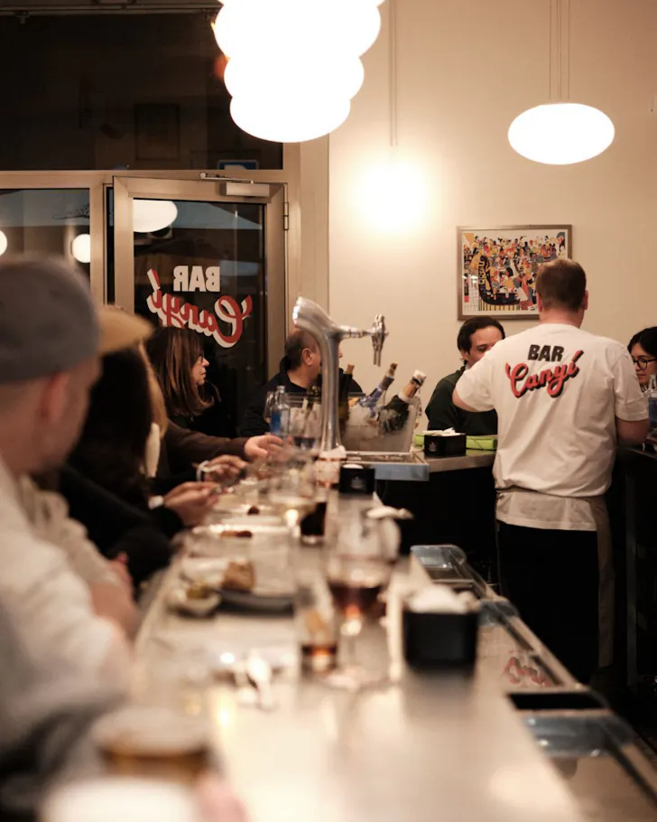 The stainless steel benchtop at Bar Canyi is packed with diners. 